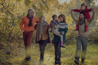 Happy extended family enjoying in autumn day together while walking in the park.
