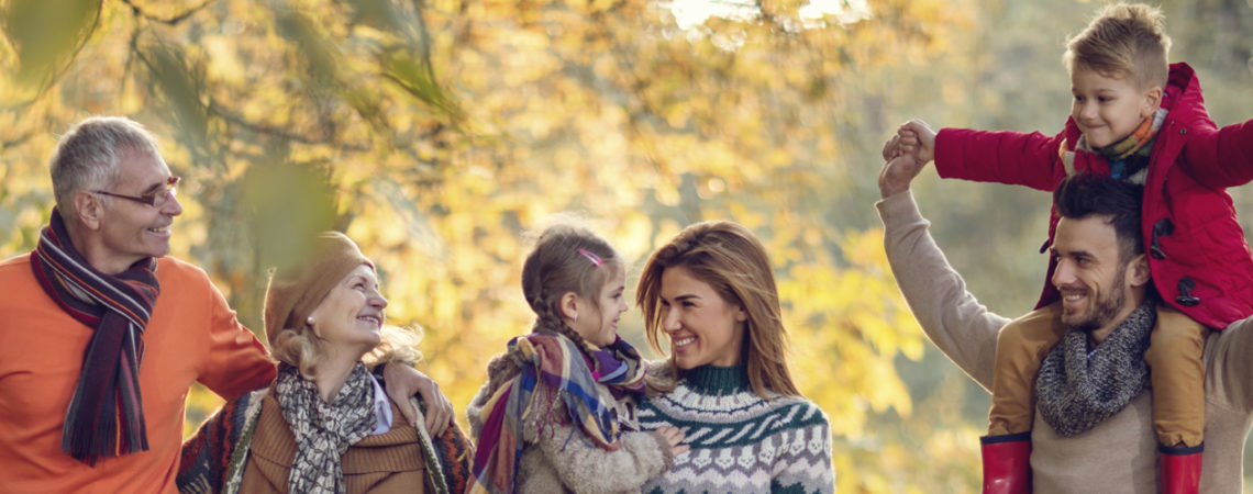 Happy extended family enjoying in autumn day together while walking in the park.